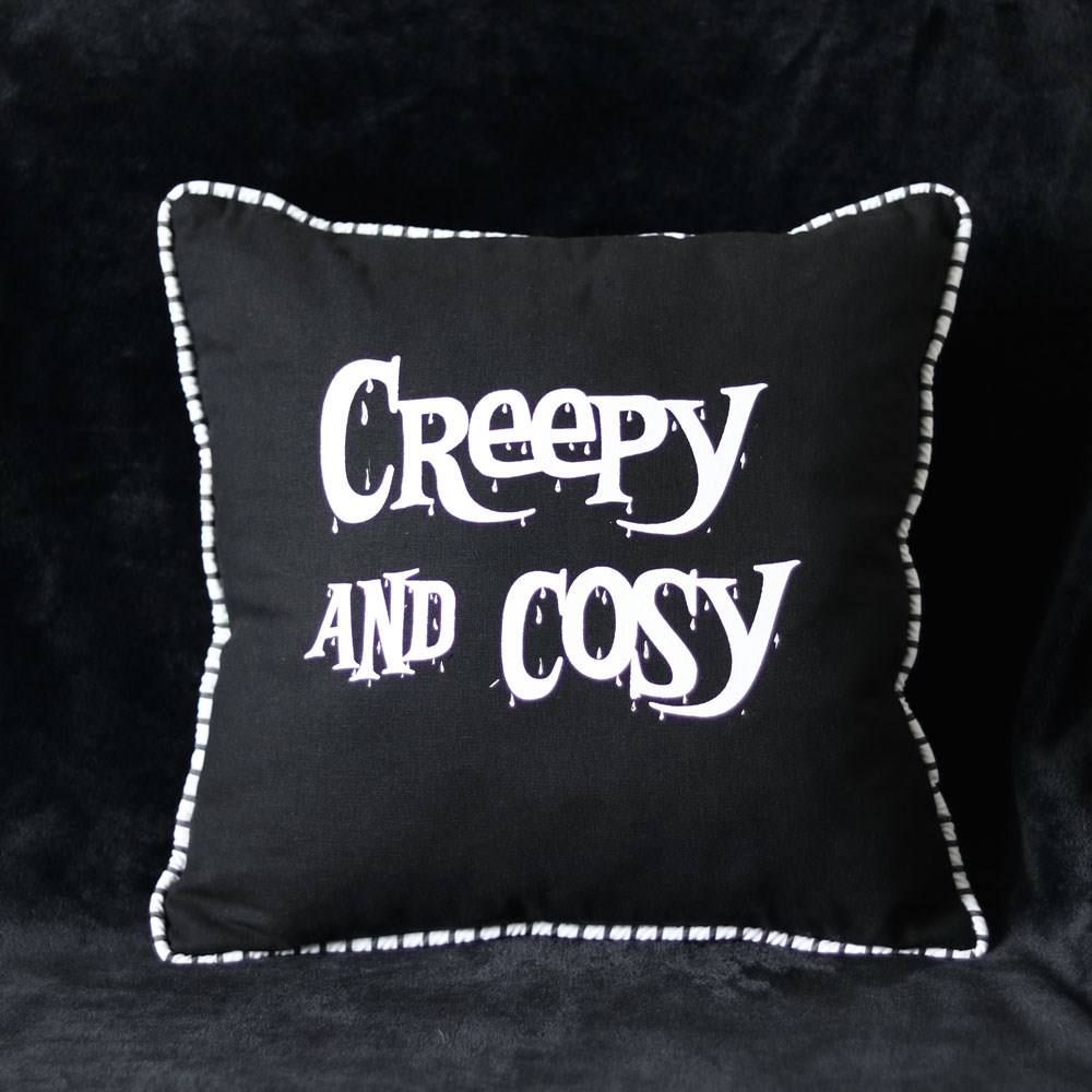 Creepy & Cosy Cushion. A black square cushion with black and white piping and white lettering saying 'Creepy and Cosy'