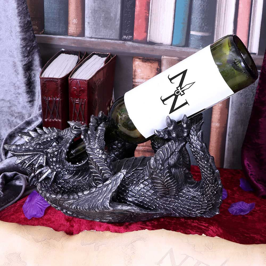 Dragon Guzzler Wine Bottle Holder by Nemesis Now. A dragon laid on its back holding a bottle in its back and front legs with the neck of the bottle in its mouth 