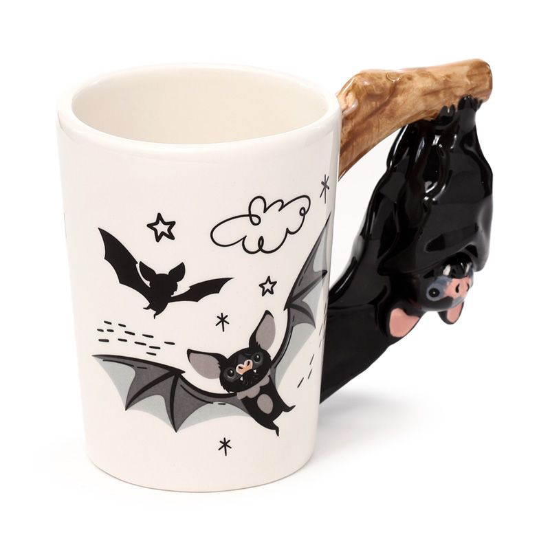 Bat shaped handle mug. A cream coloured large mug with adorable bat graphics and a bat hung upside down on a branch as the handle. An awesome gift for a gothic fan.