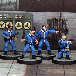 Minion with Hand Weapons by Crooked Dice, a set of four 28mm scale metal miniatures depicting henchmen wearing matching blue uniforms and black boots, with all four holding hand weapons (two with hand guns and two with truncheons) and one down on one knee pointing his gun forward