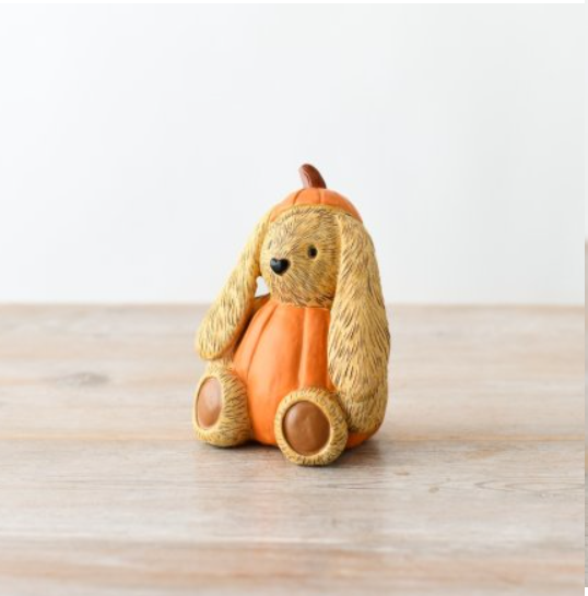 An adorable autumnal bunny ornament. The cute rabbit figurine is dressed as a pumpkin, sitting down with long ears and a heart shaped nose. Perfect for adding a playful touch to your home décor