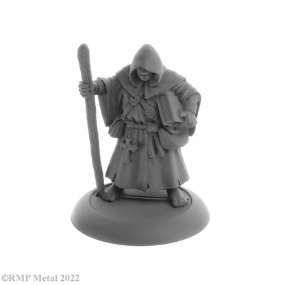 Brother Hammond from the Dark Heaven Legends metal range by Reaper Miniatures sculpted by Bobby Jackson. Holding a wooden staff in one hand and a book tucked under his other arm Brother Hammond has the hood of his robe up and walks barefoot