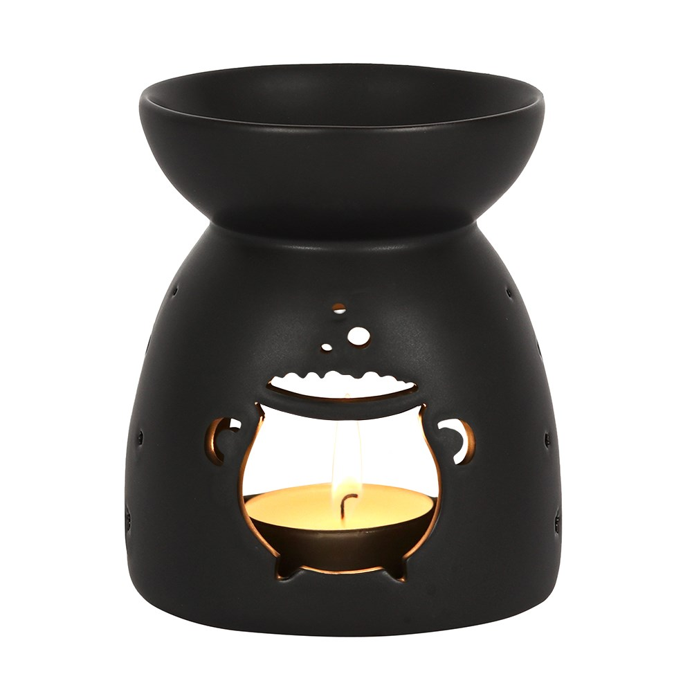 A matt black oil burner with a cut out bubbling cauldron design 