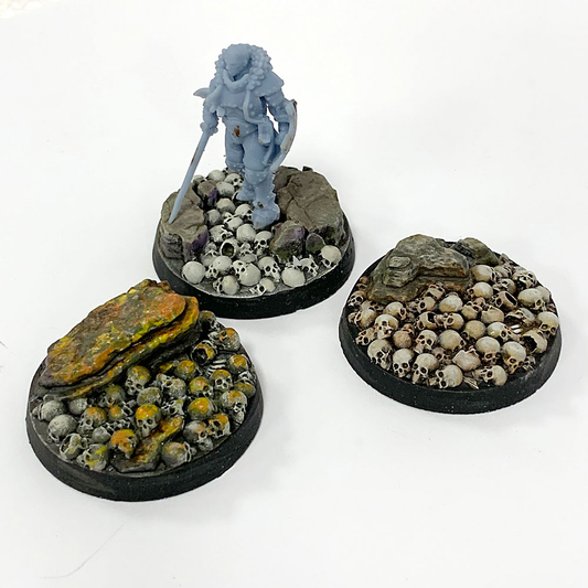 A pack of five resin 25mm bases adorned with skulls