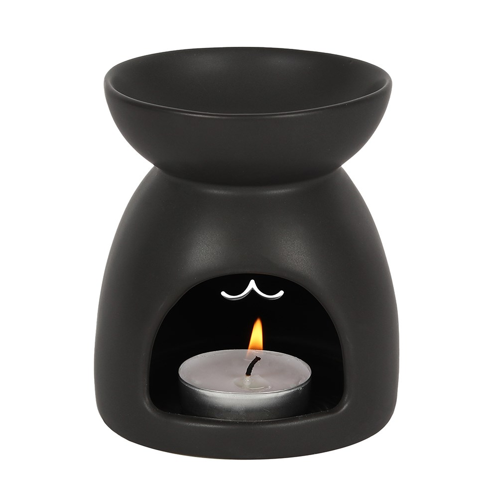 A matt black oil burner with a cut out cat face design