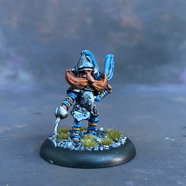 The Knight by Northumbrian Tin Solider from their Nightfolk range pre painted by Mrs MLG.  A metal miniature knight with a blue adornment to his helm and a rather excellent moustache. 