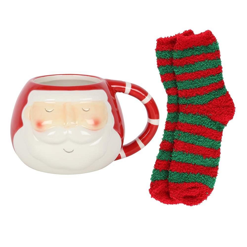  A rounded mug with Santa face design and red and white stripe handle with a pair of red and green stripped fluffy socks