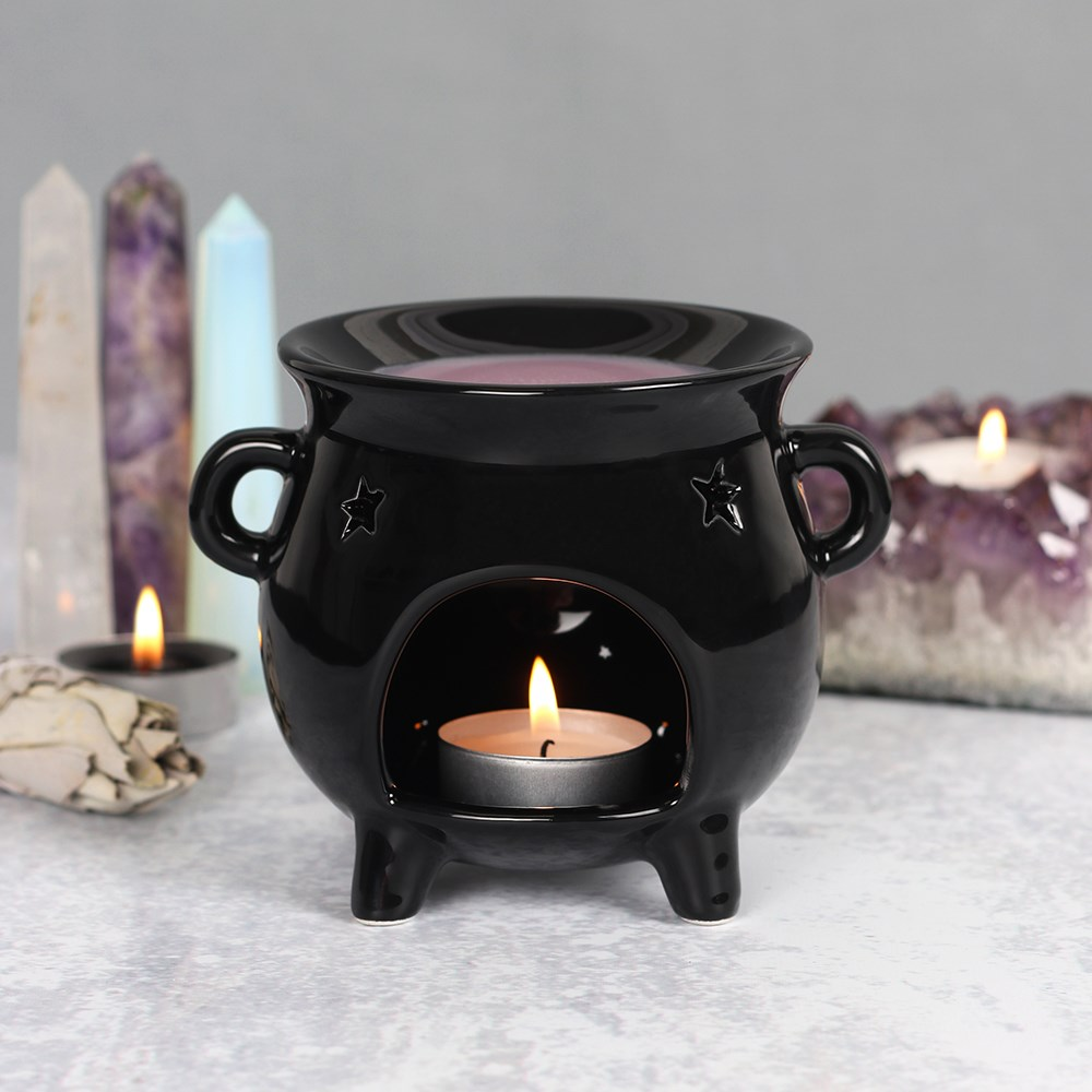 A black cauldron design oil burner with cut out star designs