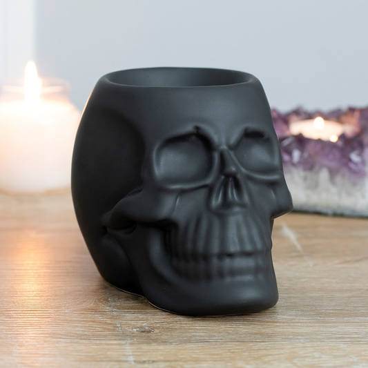 A matt black skull oil burner