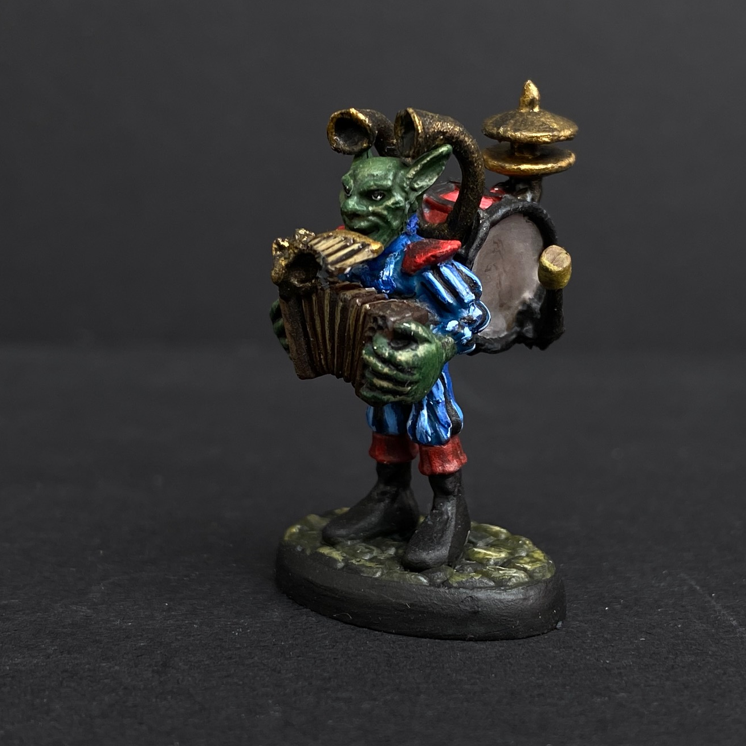 Hand painted one man band from the Reaper Miniatures range. Mrs MLG has painted this wonderful little goblin playing all his instruments for the one man band using a blue and red colour scheme for his clothing. 