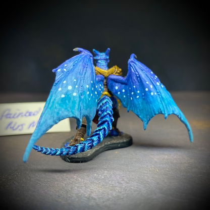  dragonfolk rouge holding a dagger in one hand and a pouch in the other. Mrs MLG has painted this miniature with a blue palette adding white dot effects to the wings, the armour is golden colour and Tazythas has a red loin cloth.