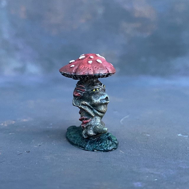 A Reaper Miniatures Mushroom Man hand painted by Mrs MLG. Painted with brown and reds and having yellow eyes this is a cute little fella is in a walking stance and looks as though his is whistling as he walks along.